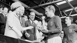 Die Queen überreicht Bobby Moore einen Pokal