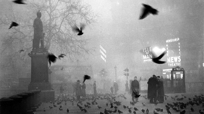 Trafalgar Square in London am 5. Dezember 1952. Menschen gehen im dunklen Dunst über die Straße.