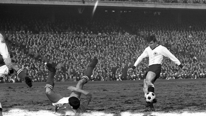 Die deutsche Fußballnationalmannschaft und Italien trennen sich in einem Testspiel 1:1 unentschieden im Hamburger Volksparkstadion am 13. März 1965. Deutschlands Wolfgang Weber (r) schießt den Ball. 