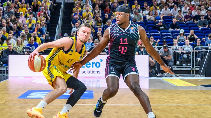 Berlins Martin Hermannsson dribbelt gegen Brian Fobbs von den Telekom Baskets Bonn