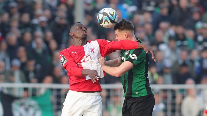 Luftzweikampf zwischen Tarsis Bonga (Hallescher FC) und Niko Koulis (Preußen Münster)