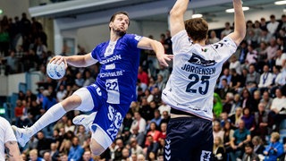 Kentin Mahe (l., VfL Gummersbach) im Wurf, Lukas Jorgensen (SG Flensburg-Handewitt) versucht, abzuwehren.