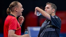 Hannes Dösseler (l.) spricht mit einem Athleten bei den Paralympics