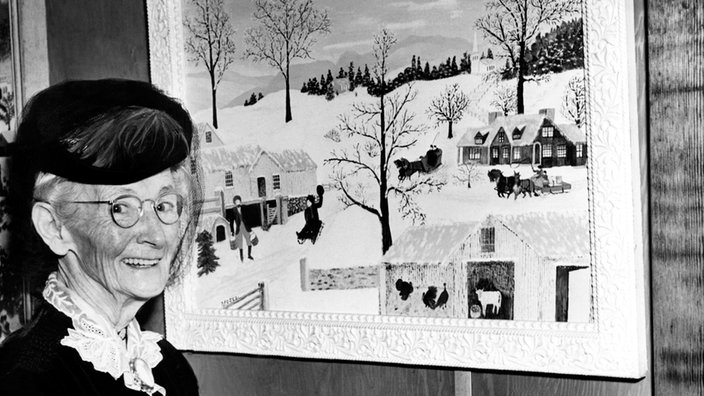 Grandma Moses, vor einem ihrer Winternilder stehend (Foto s/w)