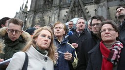 Peter Biesenbach steht in Köln vor dem Hauptbahnhof neben der CDU-Obfrau Ina Scharrenbach  und dem Polizeidirektor Georg Schulz  auf der Freitreppe