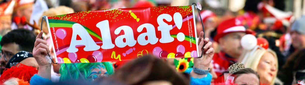 Köln Karneval feiernde Menschen: Detailaufnahme von einem Schild auf dem "Alaaf" steht. 