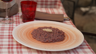 Das Bild zeig einen Teller mit einer bräunlich roten Reisspeise.