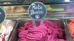 Rosafarbenes Eis mit einem Schild auf dem "Rote Beete" als Geschmacksrichtung steht.