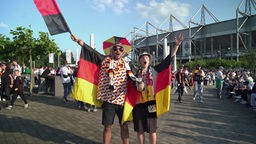 Zwei Fans bekleidet mit Fanartikeln.