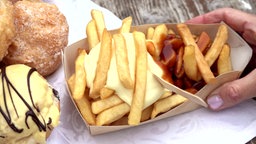 Das Bild zeigt Berliner, Windbeutel und Pommes rot weiß von oben.