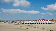 Das Bild zeigt einen Strand mit kleinen Häuschen in den Niederlanden. 