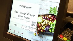 Das Bild zeigt eine Selbstscan-Kasse in einem Supermarkt. 