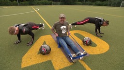 Das Bild zeigt Doc Esser am trainieren mit einem Resistance Band auf einem Football-Feld.