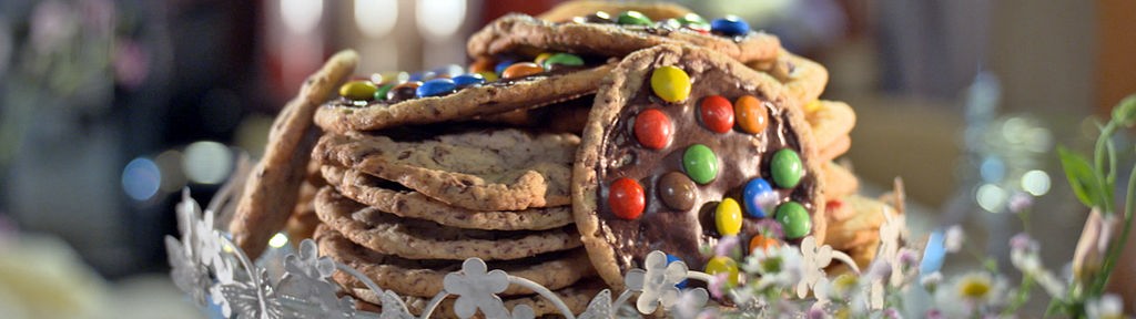 Mehrere Cookies mit Schokolinsen verziert werden auf einem Teller präsentiert