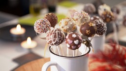 Die Cake-Pops stehen in einer Tasse.