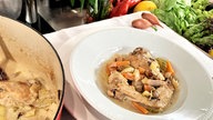 Coq au Riesling in einem Teller angerichtet