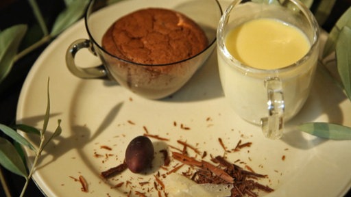 Schokoladenkuchen in einem Glas, angereichtet auf einem Teller mit Vanillesoße