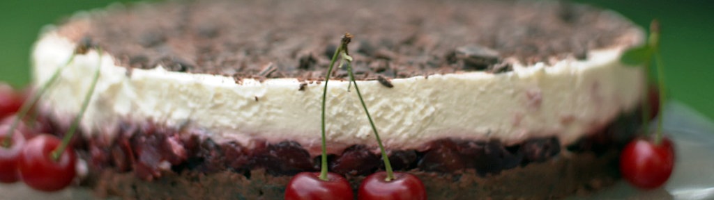 Der westfälische Quarkkuchen mit Kirschen angerichtet auf einer Kuchenplatte