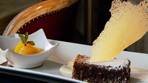 Brownie verziert mit Karamellblatt, angerichtet mit Kaffee-Karamellsahne und Mandarinen 