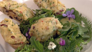 Brotscheiben mit Eiermösch belegt, garniert mit Blüten und Kräutern