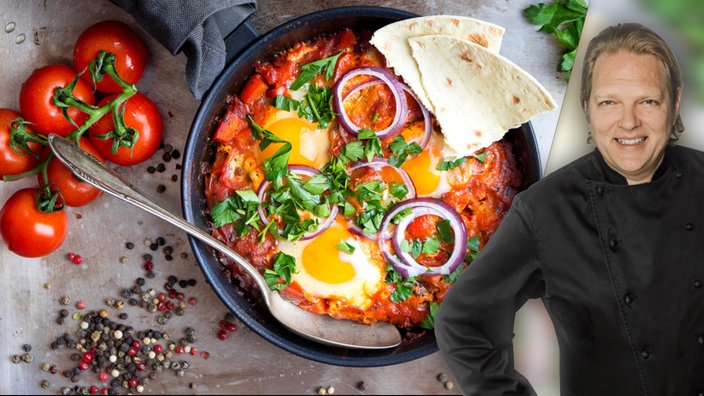 Das Bild zeigt Björn Freitag mit dem Gericht "Shakshuka" im Hintergrund.