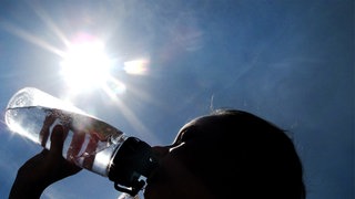 Ein Mädchen trinkt in Dortmund Wasser aus einer Flasche.